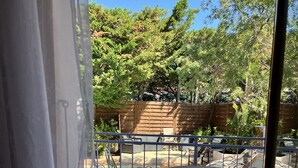 Un patio con piscina, mobiliario exterior y cerramiento de madera.