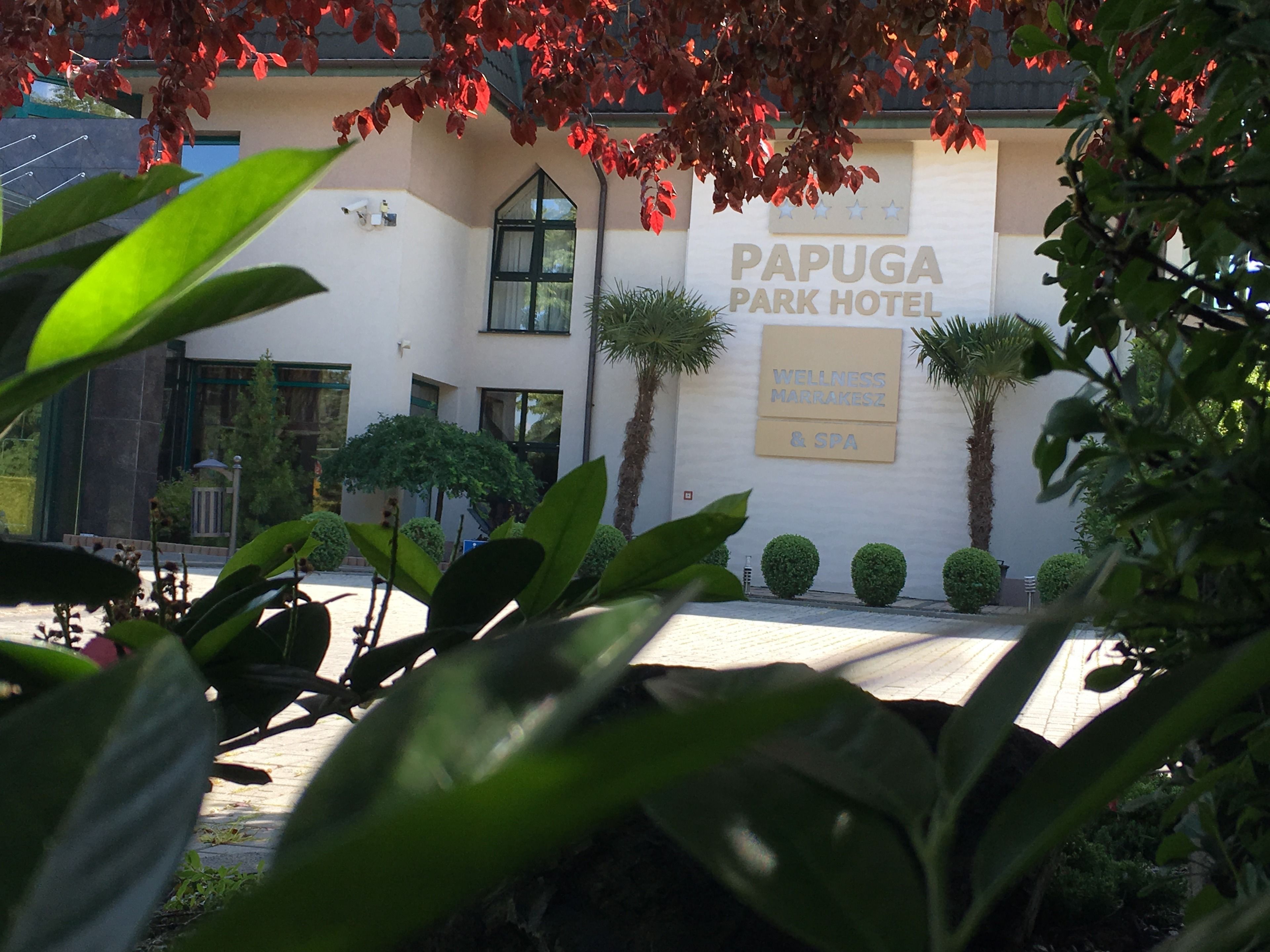 The exterior of the Papuga Park Hotel with a sign indicating it offers wellness, Marrakesh, and spa services.