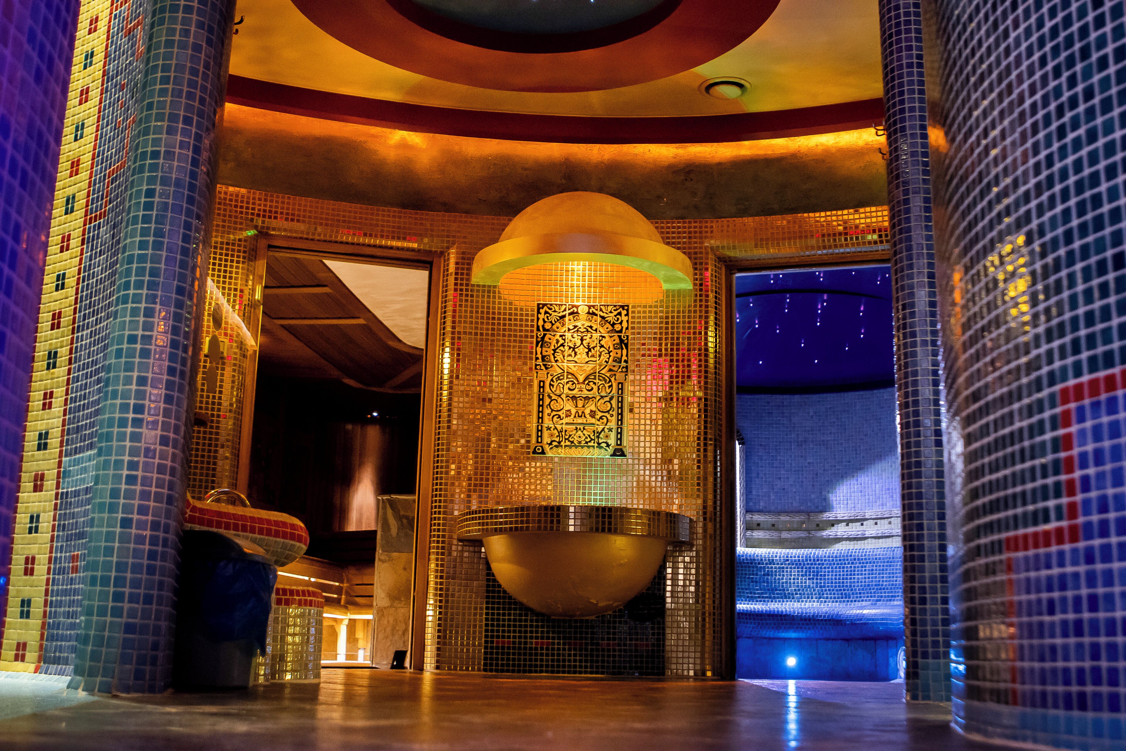 A modern interior with a large decorative bowl, tiled walls, and columns.