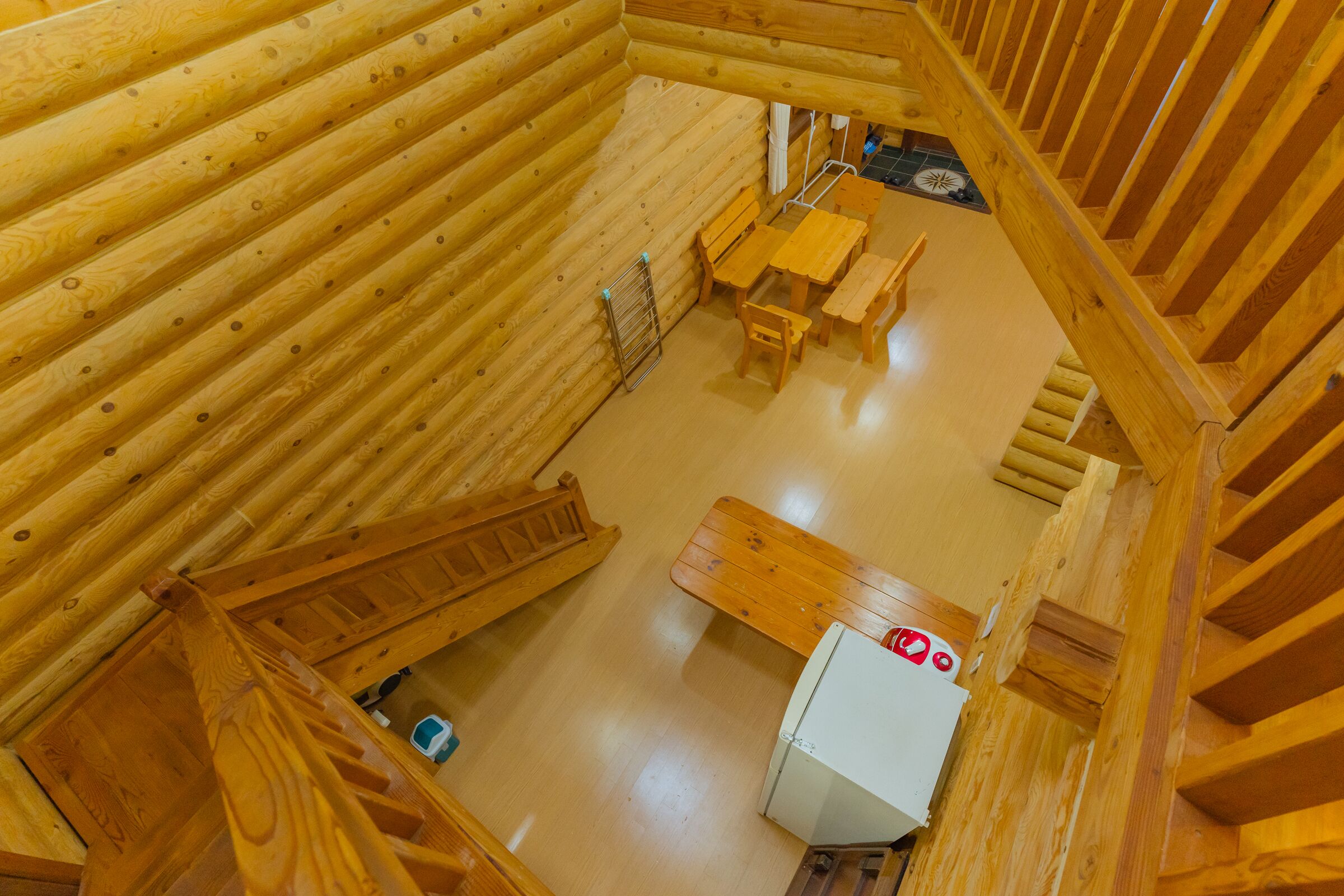 L’intérieur d’une cabane en bois comprend un coin repas, une petite cuisine et un escalier.