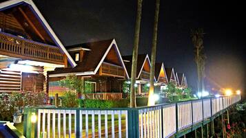 A row of wooden cabins with balconies, connected by a wooden deck.