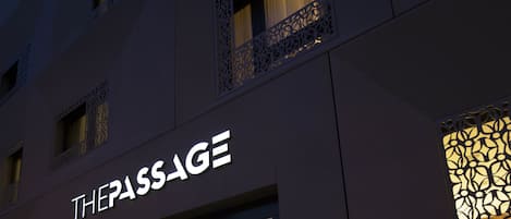 A building facade with a sign reading "THEPASSAGE" and decorative window designs.