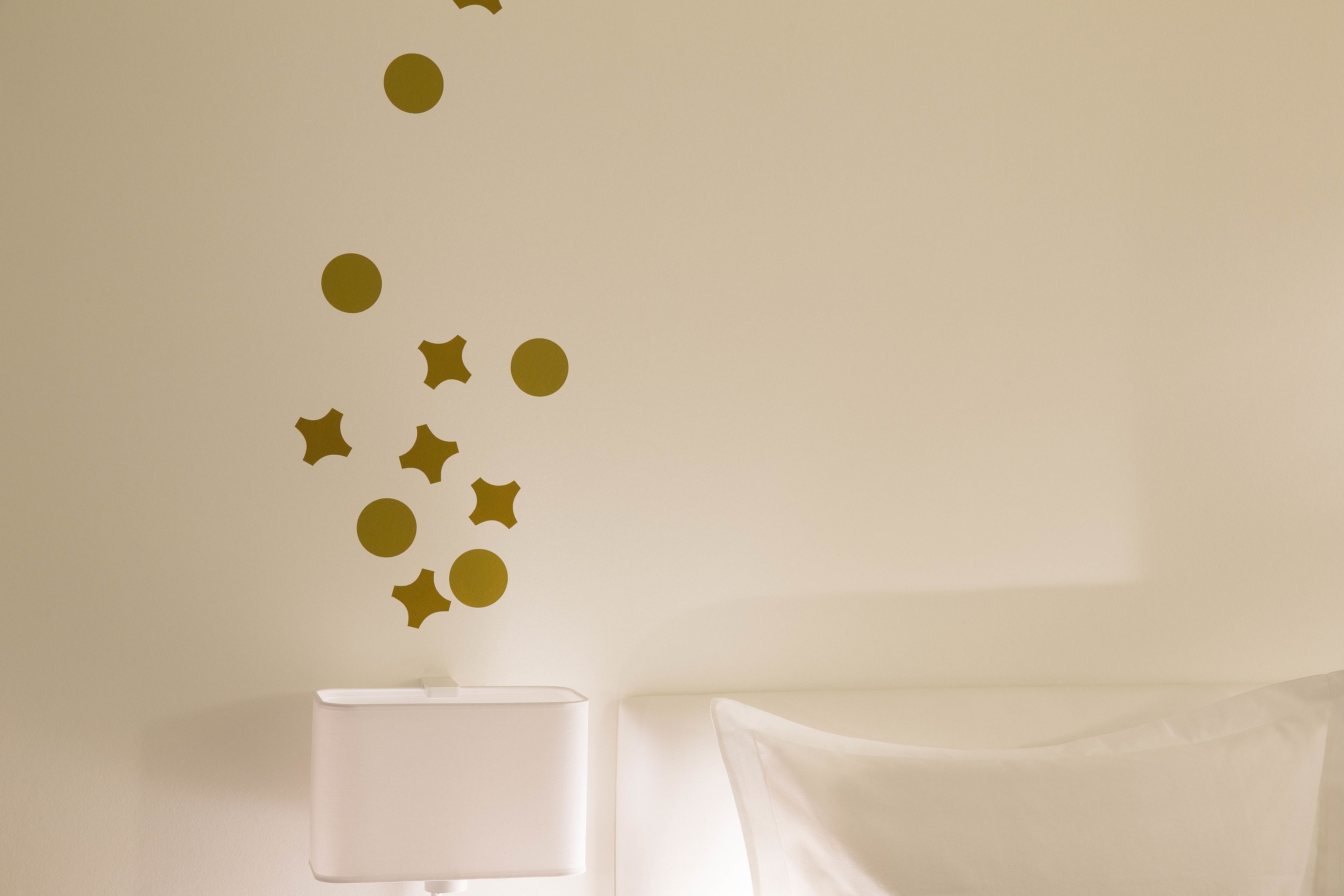 A room with a white lamp and a bed with white bedding.