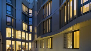 A modern building with multiple floors, large windows, and a courtyard area. - The Passage Urban & Lifestyle Hotel (Basel)