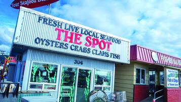 A seafood restaurant named "The Spot" with a sign indicating it serves oysters, crabs, and fish.