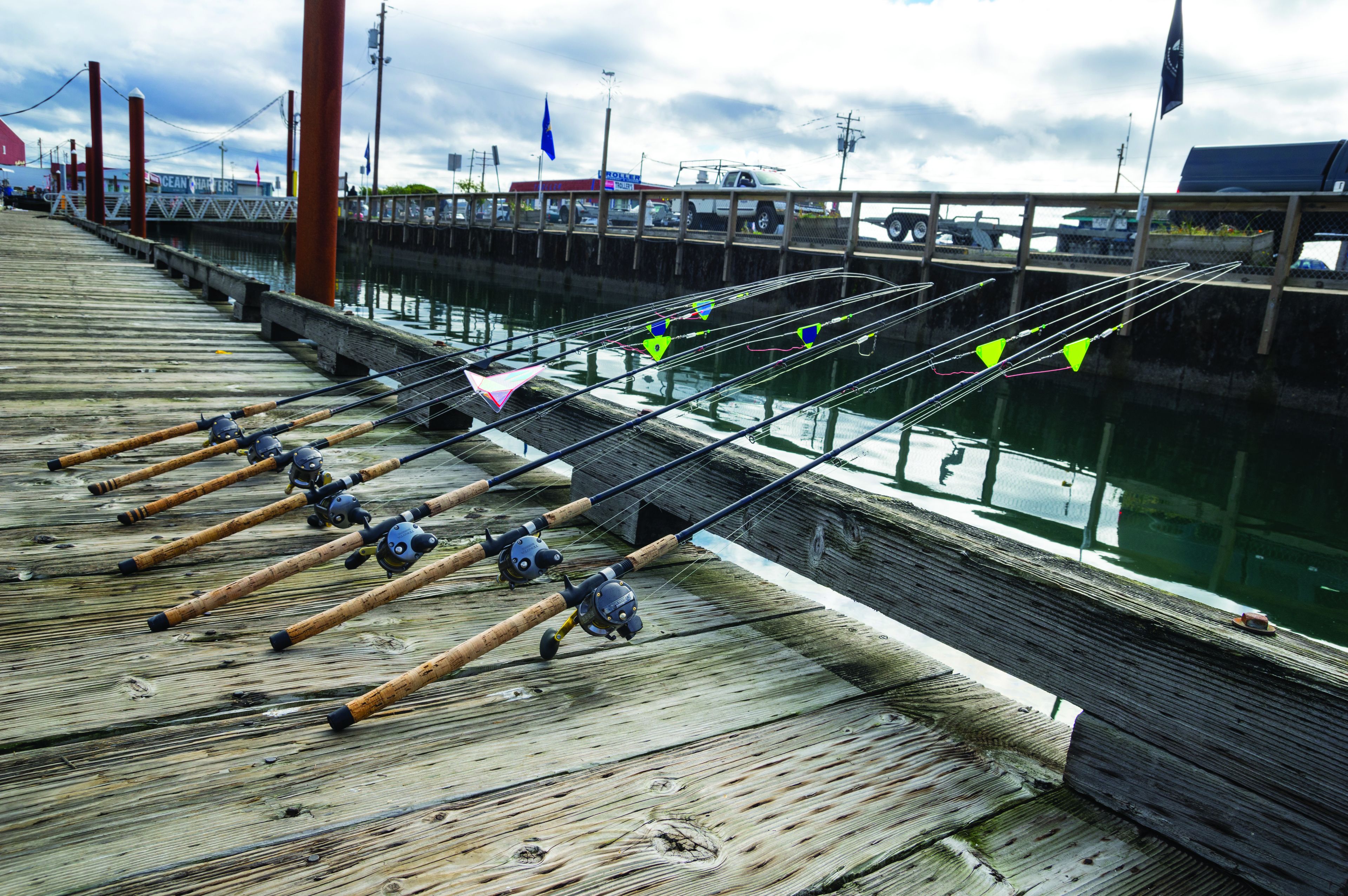 A wooden pier with fishing rods lined up.