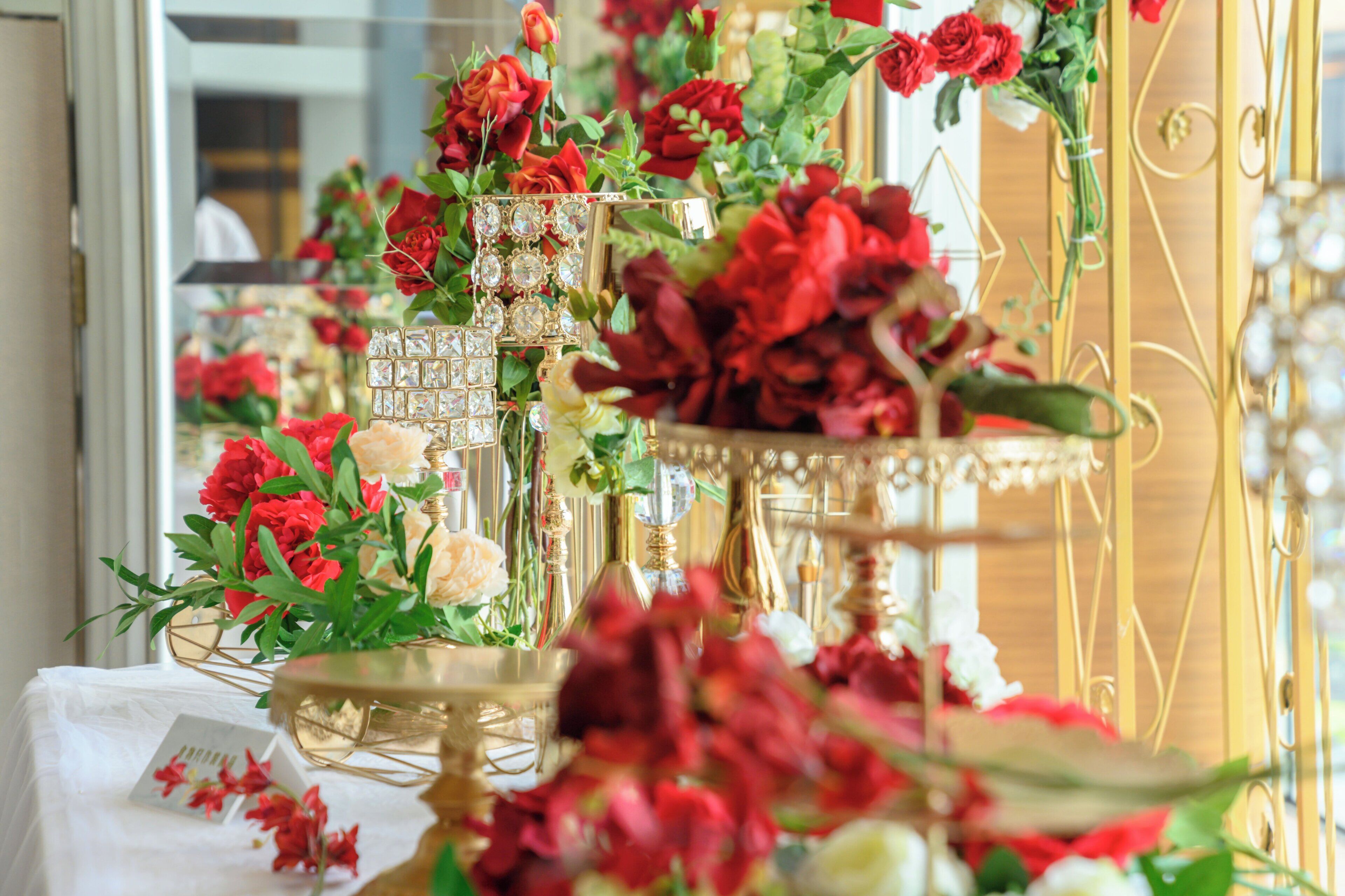 Una mesa con arreglos florales y jarrones decorativos.