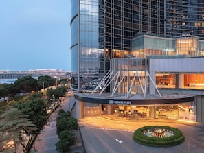 A modern building with a glass facade, a landscaped area with a circular garden, and a sign reading "Crowne Plaza". - Crowne Plaza Macau by IHG (Macau)