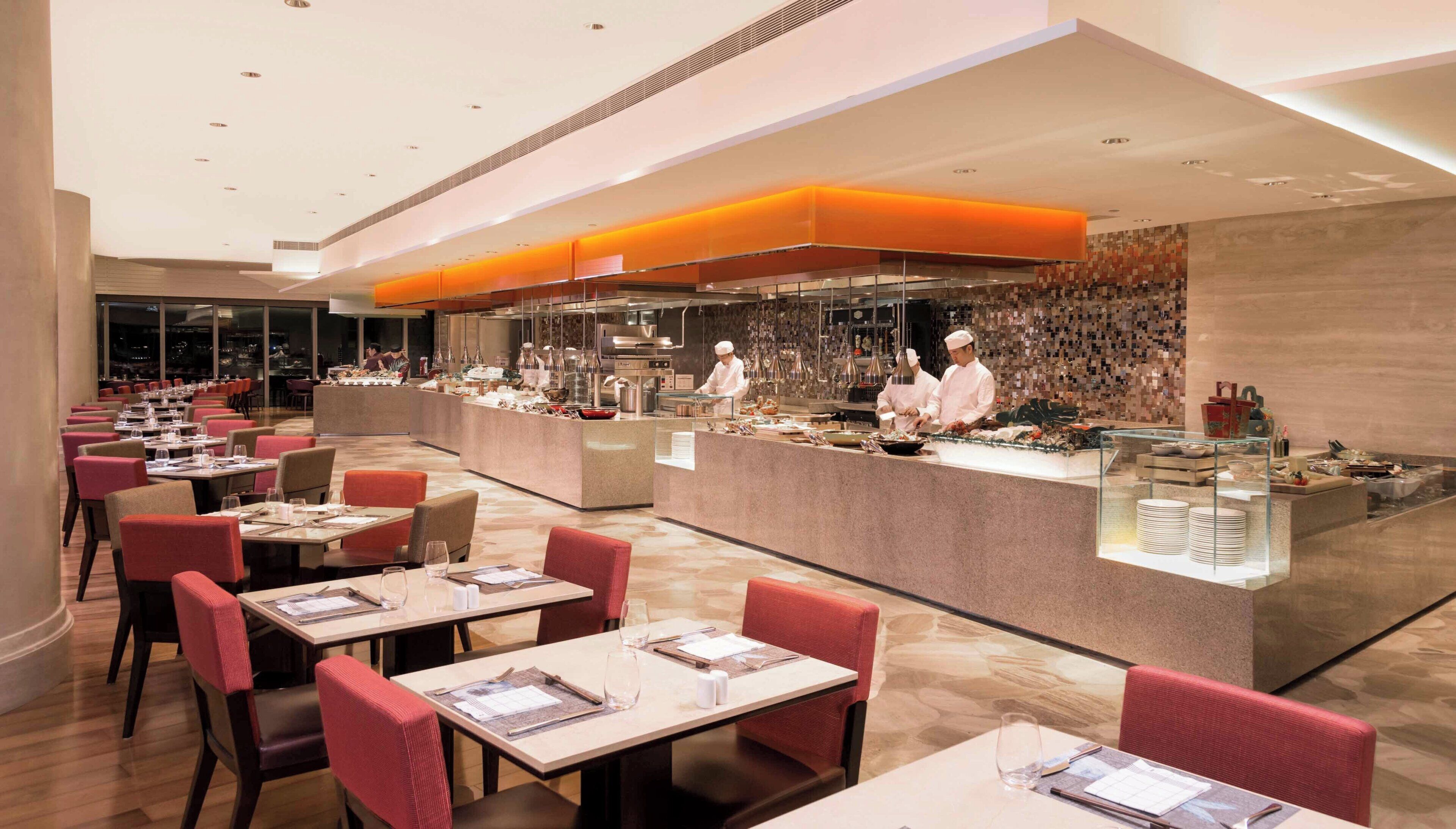 Un restaurante moderno con una barra central, varias mesas y sillas.