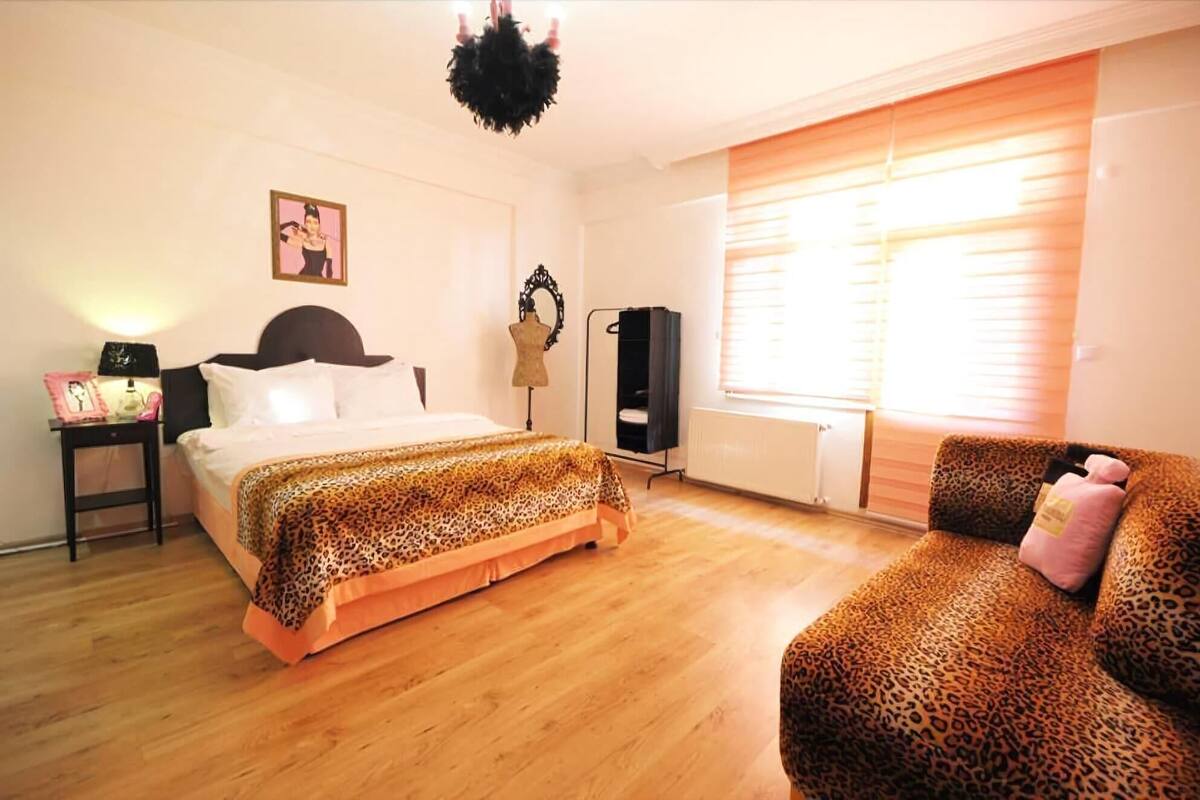 Une chambre à coucher avec un lit, une chaise, une armoire, un radiateur et un tableau accroché au mur.