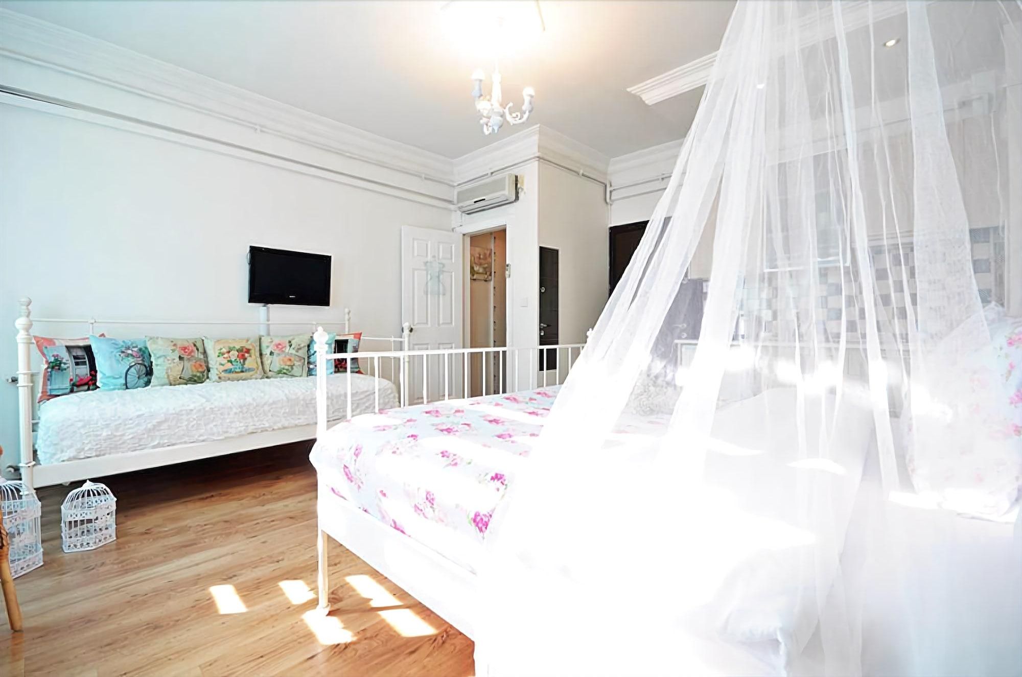 Une chambre avec un lit, un canapé, une télévision et un balcon.