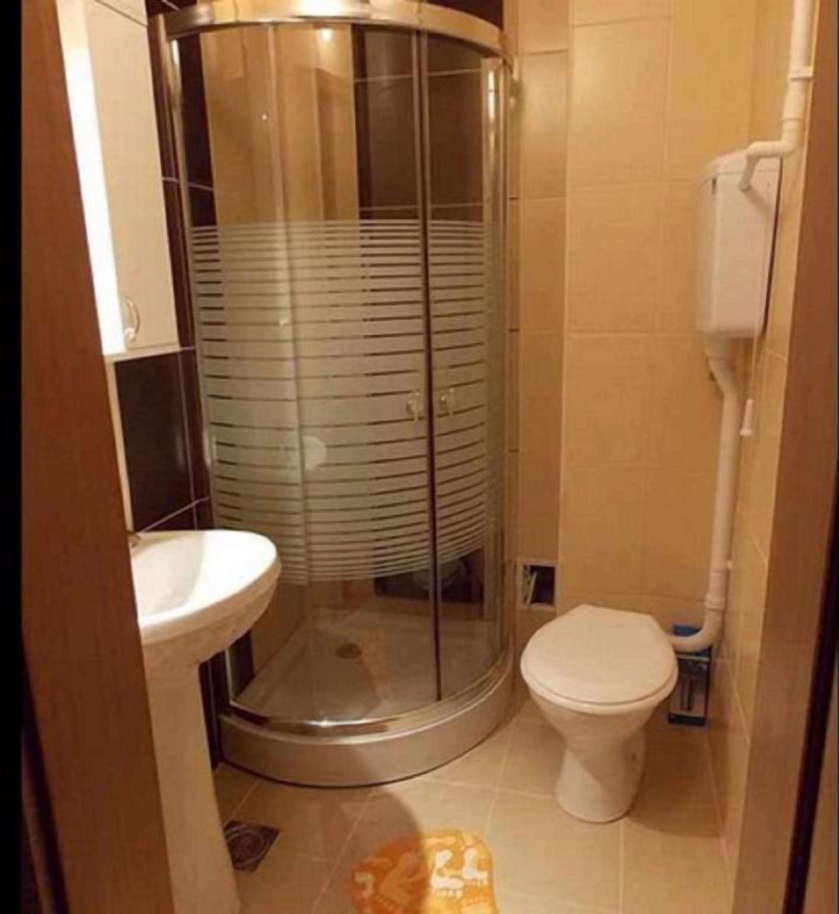 Une salle de bain avec une douche à parois de verre, des toilettes et un lavabo.