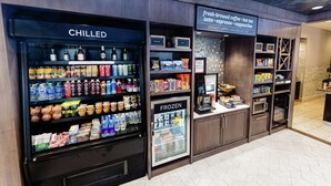 A beverage vending area with chilled and frozen drink options, a coffee specialty sign, and a microwave. - Hilton Garden Inn Exton / West Chester (Exton)