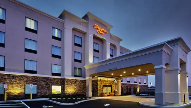 A Hampton Inn hotel with a stone facade, a covered entrance, and a parking lot. - Hampton Inn Niagara Falls/Blvd (Niagara Falls)