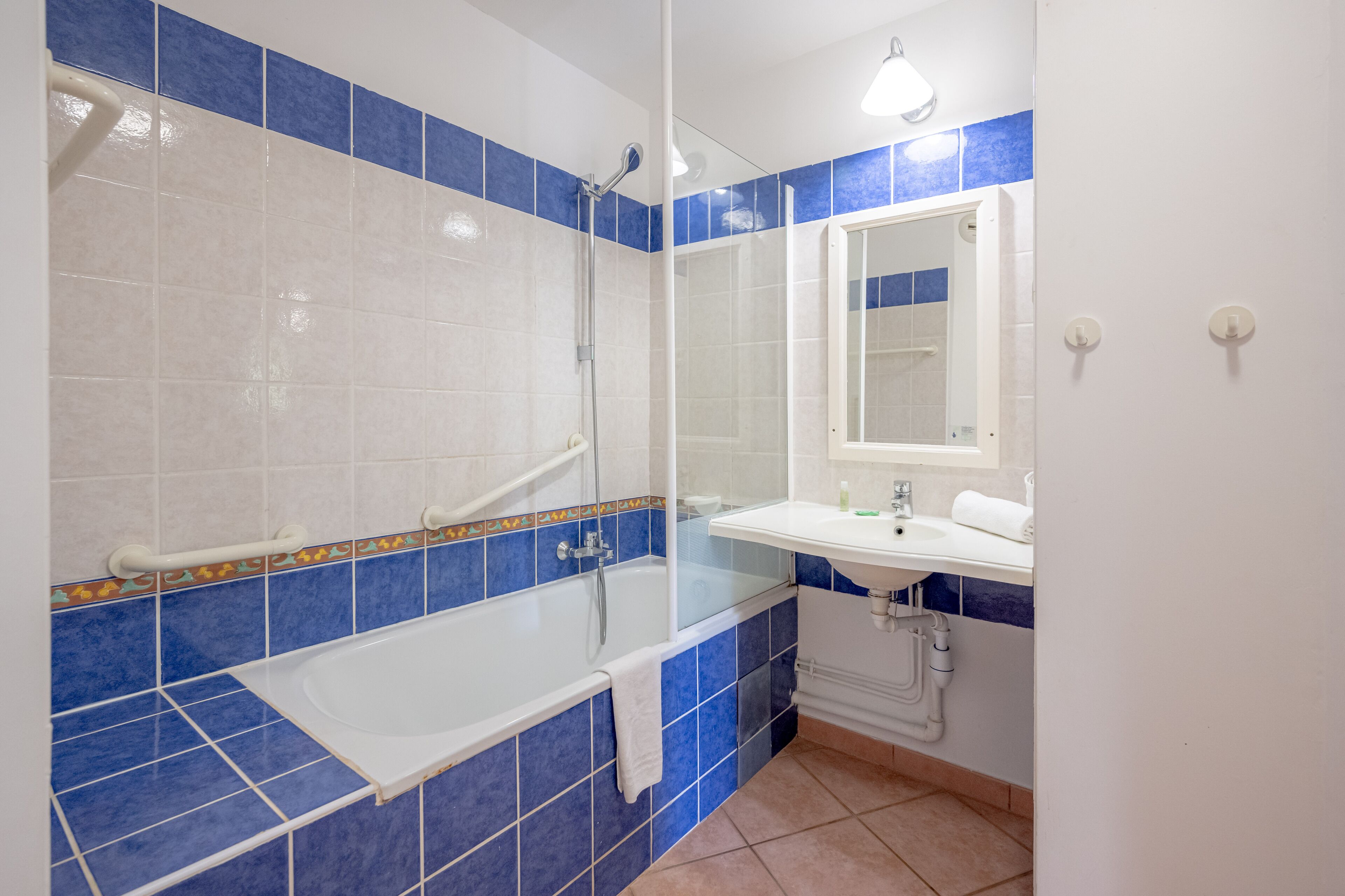 Une salle de bain avec une baignoire, un lavabo et un miroir.
