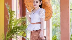 A person standing in a corridor with a large umbrella, holding a lantern. - Memoria Palace & Resort (Pailin)
