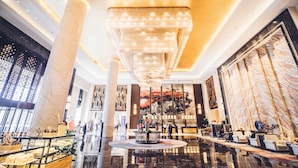 A spacious lobby with a large chandelier, marble columns, and a central fountain. - Wanda Realm Dandong (Dandong)