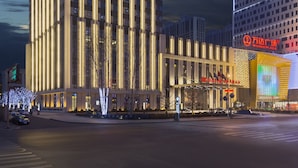 A multi-story hotel with a prominent 'Wanda Plaza' sign, featuring a modern architectural design with vertical lines and a flat roof. - Wanda Realm Dandong (Dandong)