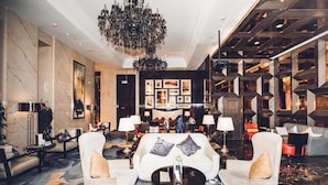 A luxurious lobby with marble walls, a grand chandelier, and modern seating arrangements. - Wanda Realm Dandong (Dandong)
