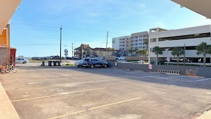 A parking lot with several cars, a stop sign, and a building with a balcony.