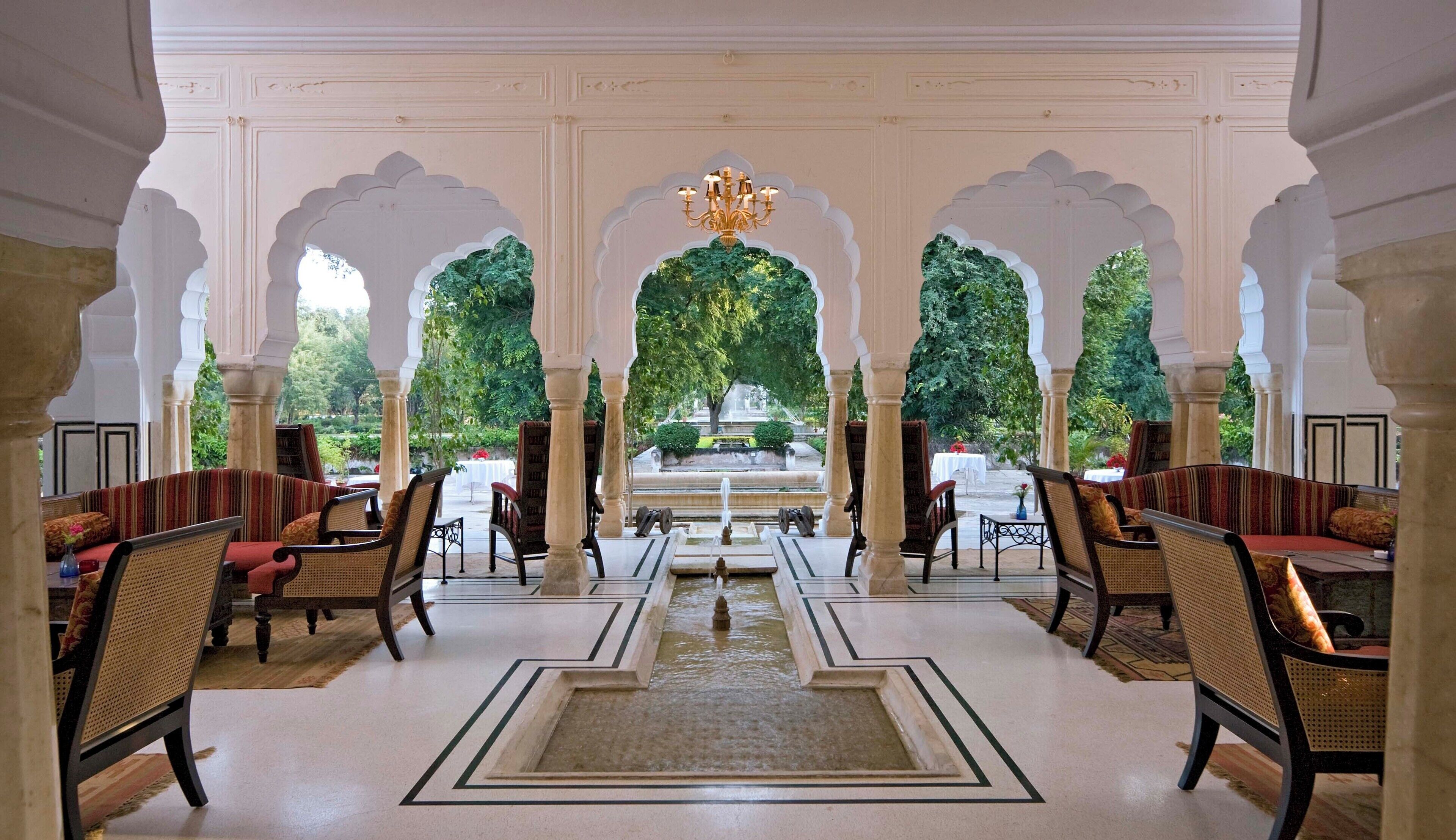 A traditional interior with a central fountain, ornate arches, and seating arrangements.