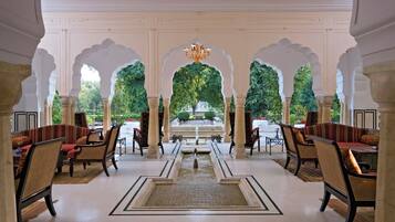 A traditional interior with a central fountain, ornate arches, and seating arrangements.