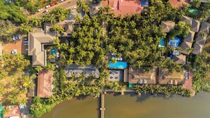 Vista aérea de una zona residencial con varias casas, una piscina y un muelle que se extiende sobre el agua.