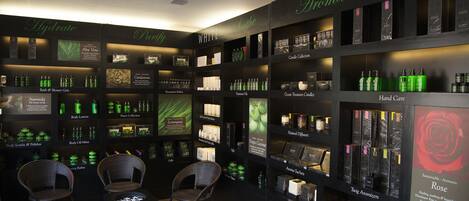 A store with shelves of various products, including body care items and essential oils.