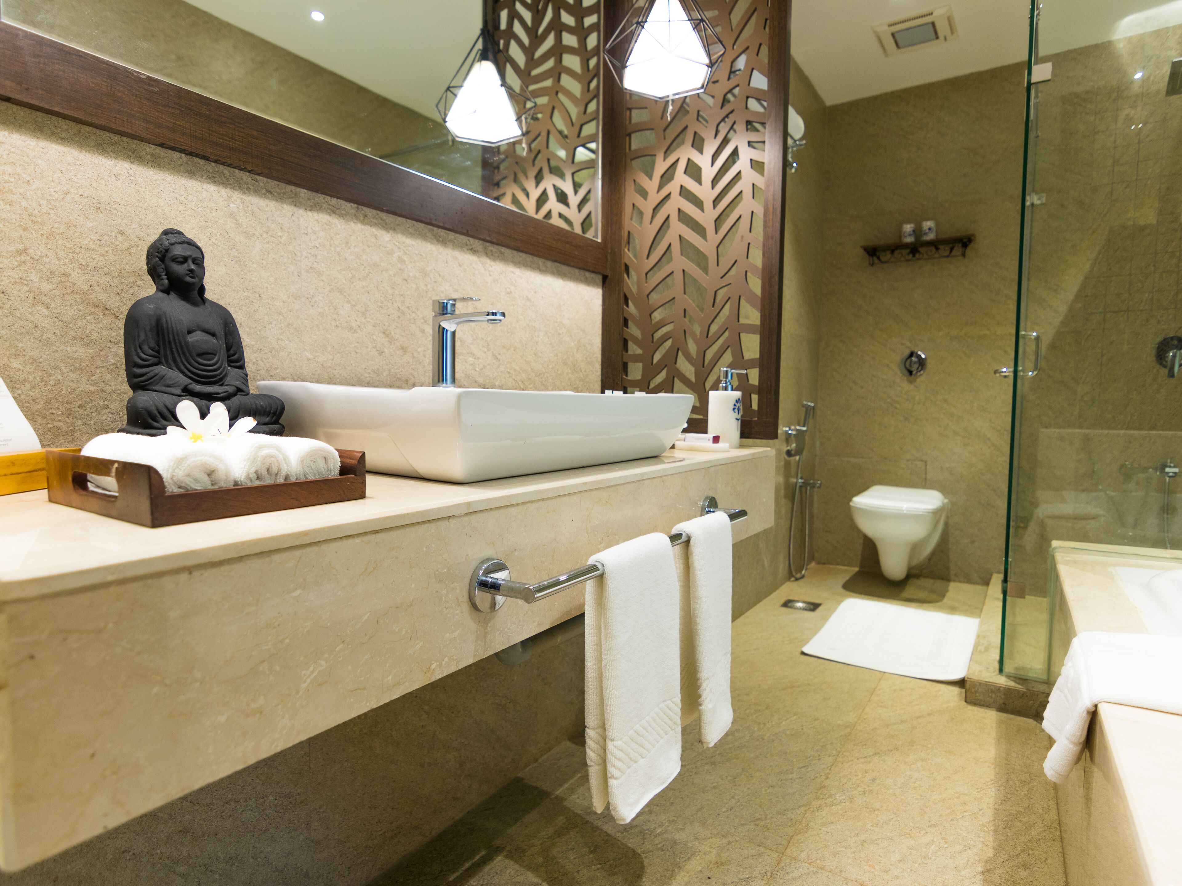 Un baño moderno con un lavamanos grande, inodoro y ducha con mampara de vidrio.