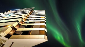 Un hotel moderno con un diseño angular único, con varios balcones y vistas al cielo nocturno.
