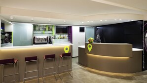 A modern bar area with a curved counter, bar stools, and a selection of beverages. - ibis Styles Lleida Torrefarrera (Torrefarrera)