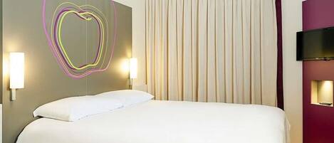 Habitación de hotel con cama, pared con diseño de luz geométrico, ventana grande con cortinas y televisor de pantalla plana montado en la pared.