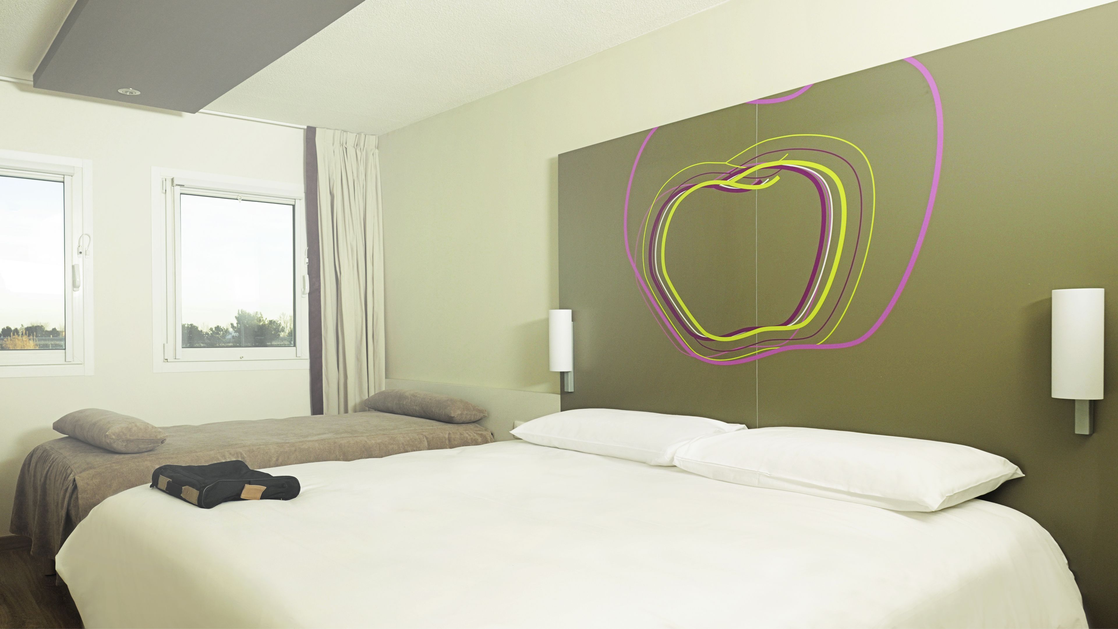 A hotel room with two beds, a large wall art piece, and two bedside lamps.
