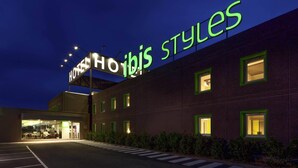 A hotel with a prominent sign reading 'HOTEL HIBIS STYLES' and a well-lit entrance. - ibis Styles Lleida Torrefarrera (Torrefarrera)