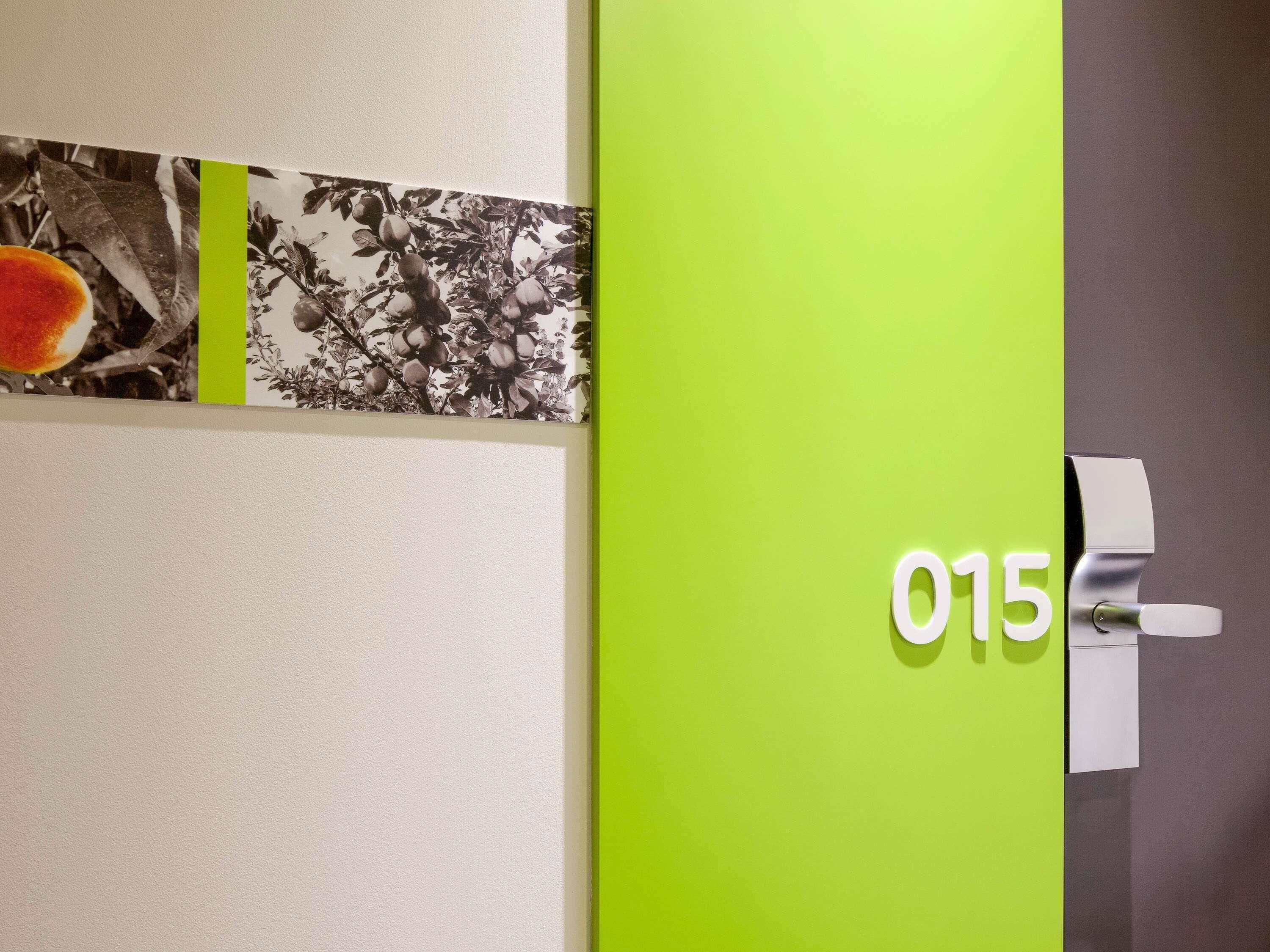 Una pared con un panel verde y un picaporte marcado con el número 015.