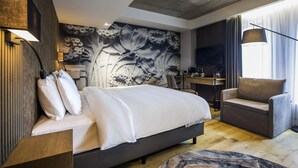 A modern hotel room with a large bed, a desk, a chair, and a television. - Mercure Riga Centre (Riga)