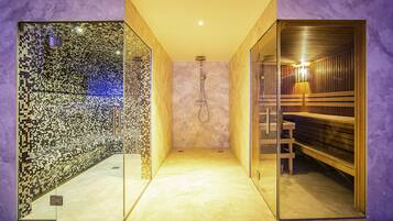 Un área de spa moderna con un muro de azulejos, una sauna de madera y un separador de vidrio.