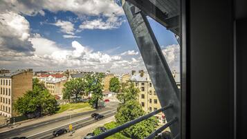 Vista de un paisaje urbano desde un puente, con edificios, árboles y una carretera.