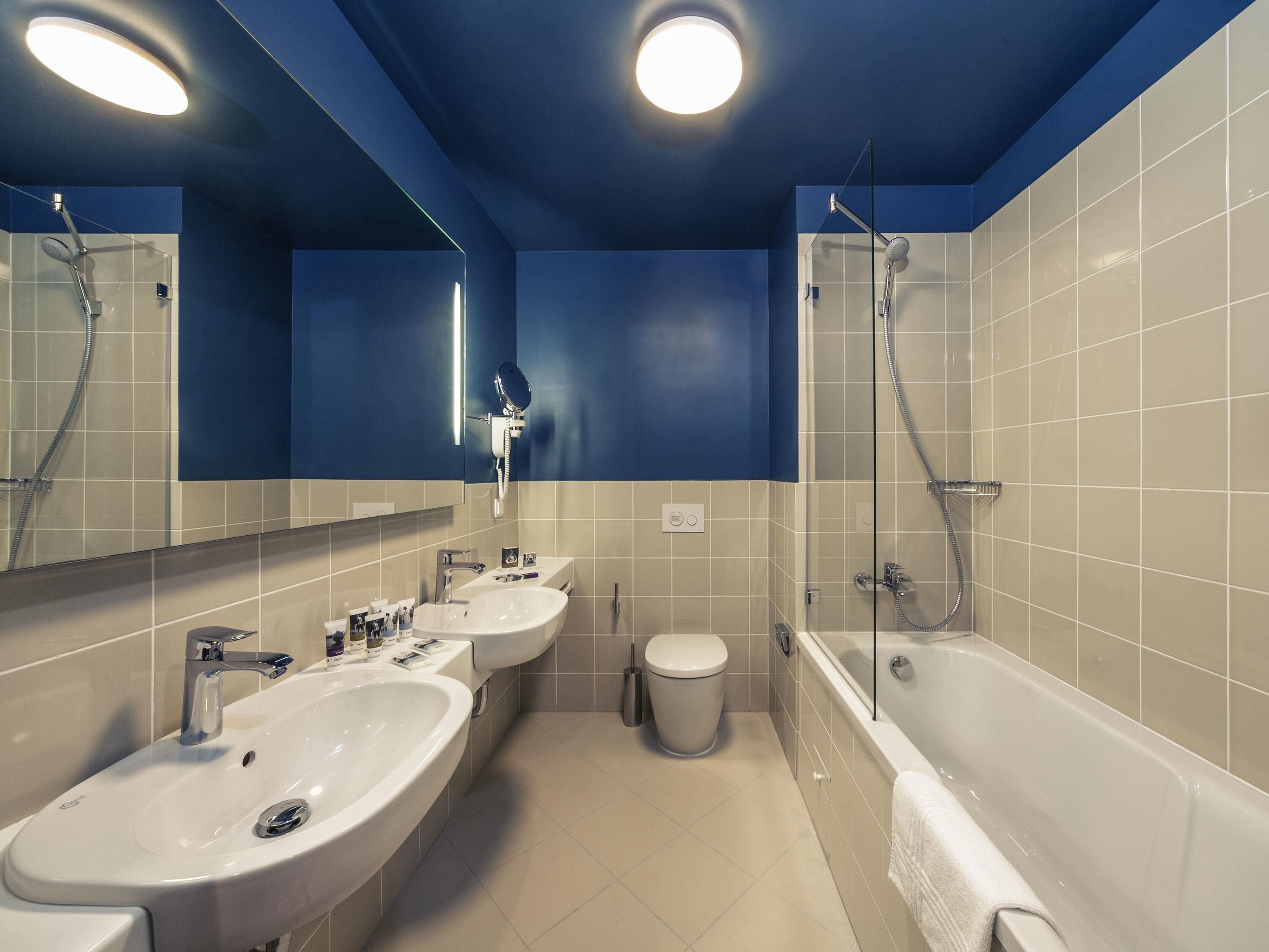 Une salle de bain moderne avec deux lavabos, des toilettes et une baignoire.