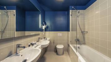 Une salle de bain moderne avec deux lavabos, des toilettes et une baignoire.