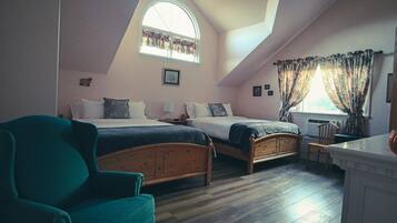 A bedroom with two wooden beds, a green armchair, a window with curtains, and a small table.