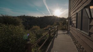 A wooden building with a balcony overlooking a forested area. - Tucker Peak Lodge (Julian)