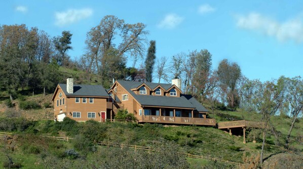 A large wooden house with multiple levels, a chimney, and a balcony. - Tucker Peak Lodge (Julian)