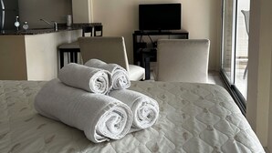 A hotel room with a bed, a desk, a chair, a television, and artwork on the wall. - Arenales Suites (Buenos Aires)