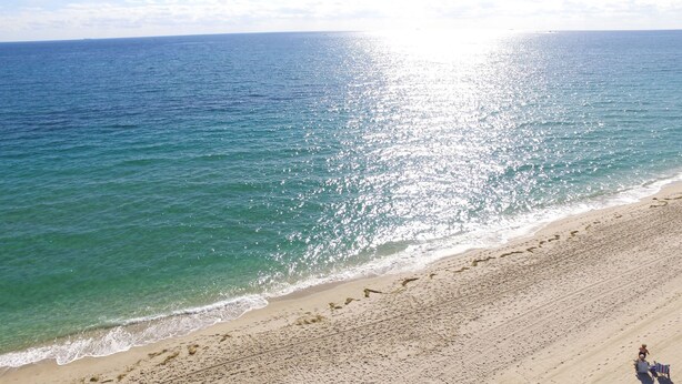 Una playa con aguas cristalinas y una extensa orilla arenosa.