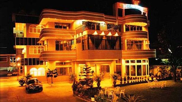 A multi-story hotel with a modern design, featuring balconies and large windows.