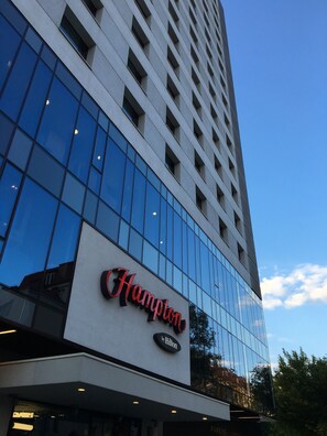 Un hôtel moderne, reconnaissable à son enseigne bien visible « Hampton by Hilton ».