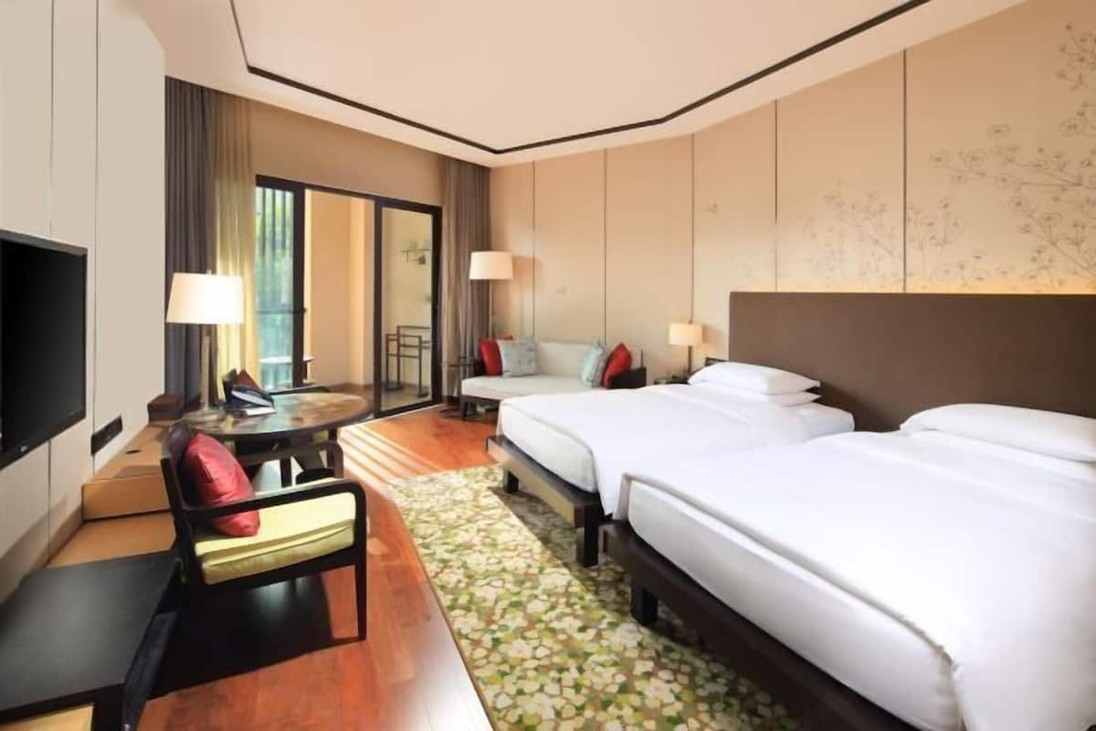Relax in this stylish room with two single beds, a flat-screen TV, and a cozy seating area.