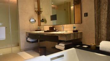 A modern bathroom with a large mirror, a bathtub, and a shower area.
