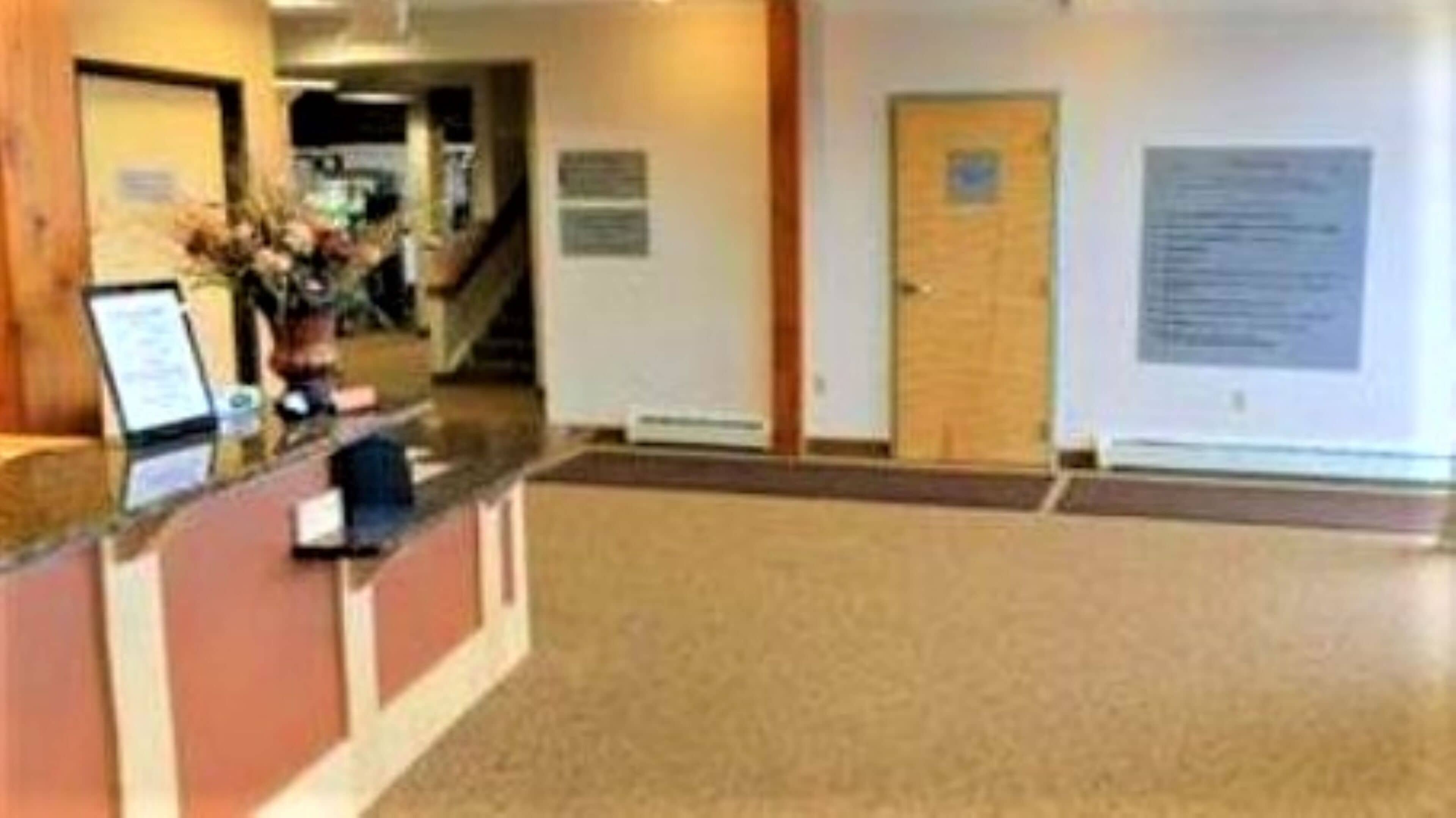 A reception area with a counter, a door, and informational signs on the walls.